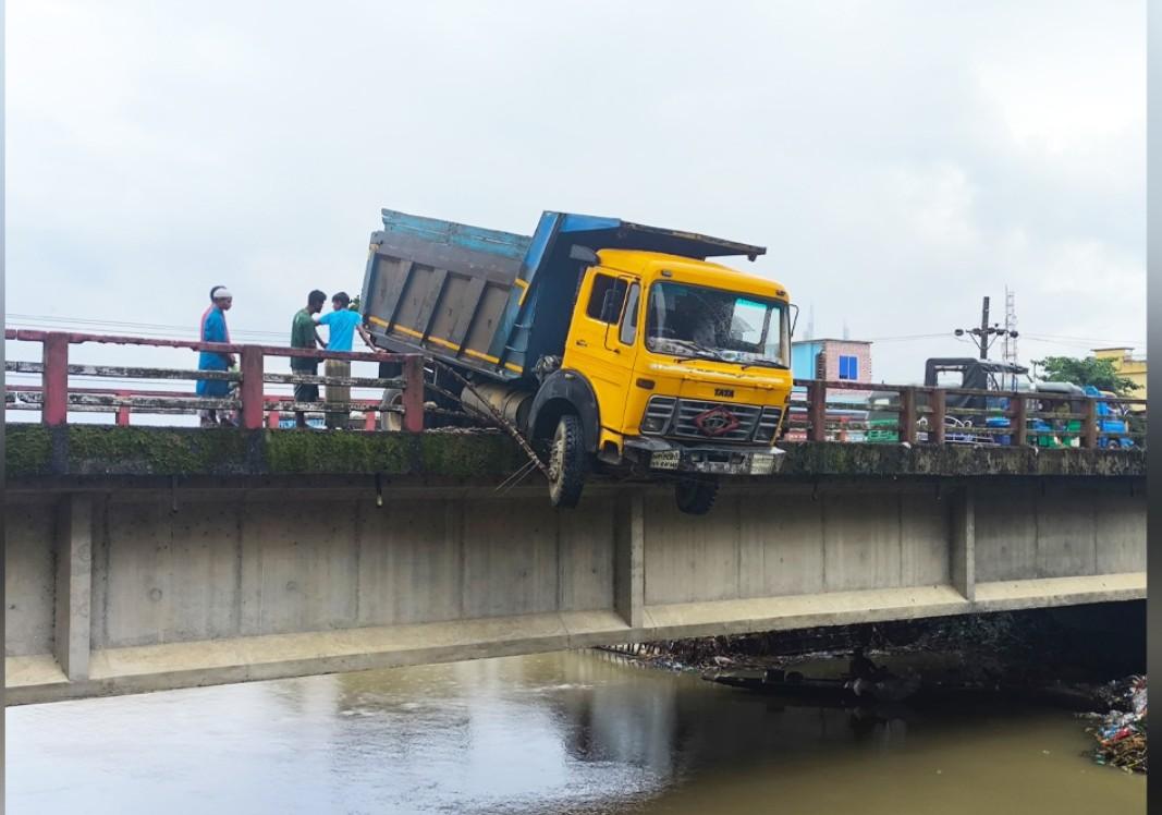 সেতুর রেলিং ভেঙ্গে ঝুলে আছে ডাম্প ট্রাক